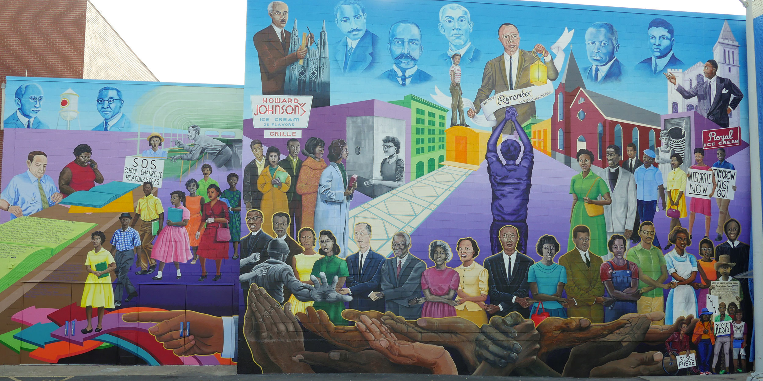 A blue, pink, yellow, and gray building mural of important and historic civil rights movement leaders in Wake County