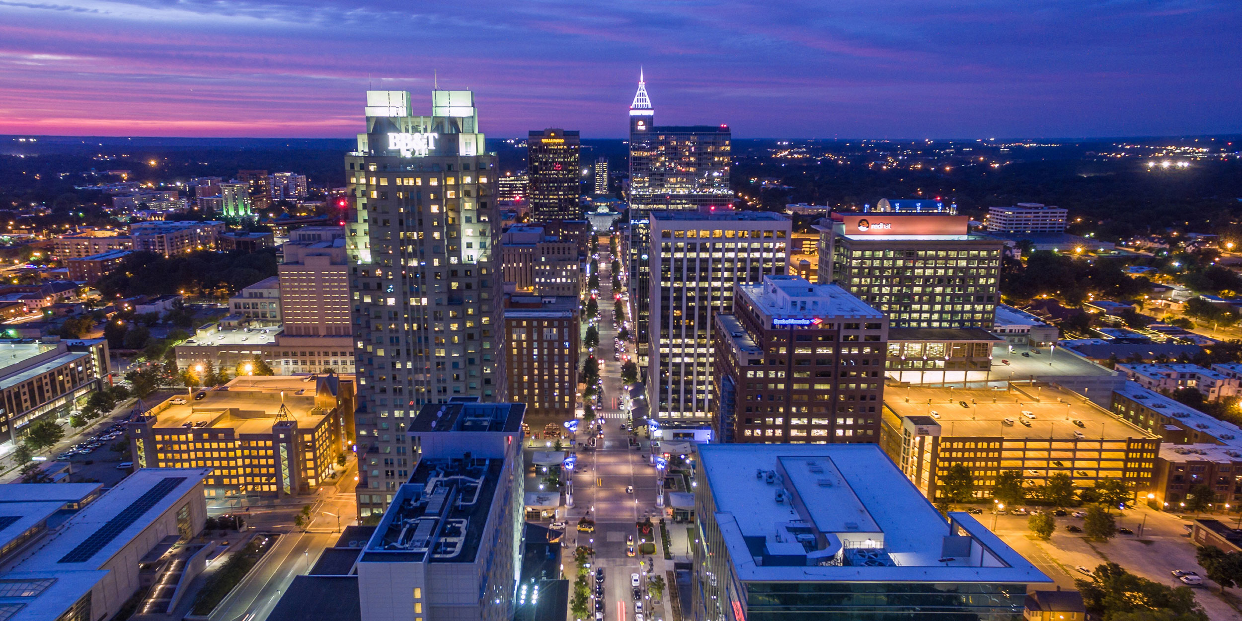 A purple sky illuminates a night time city skyline in Wake County