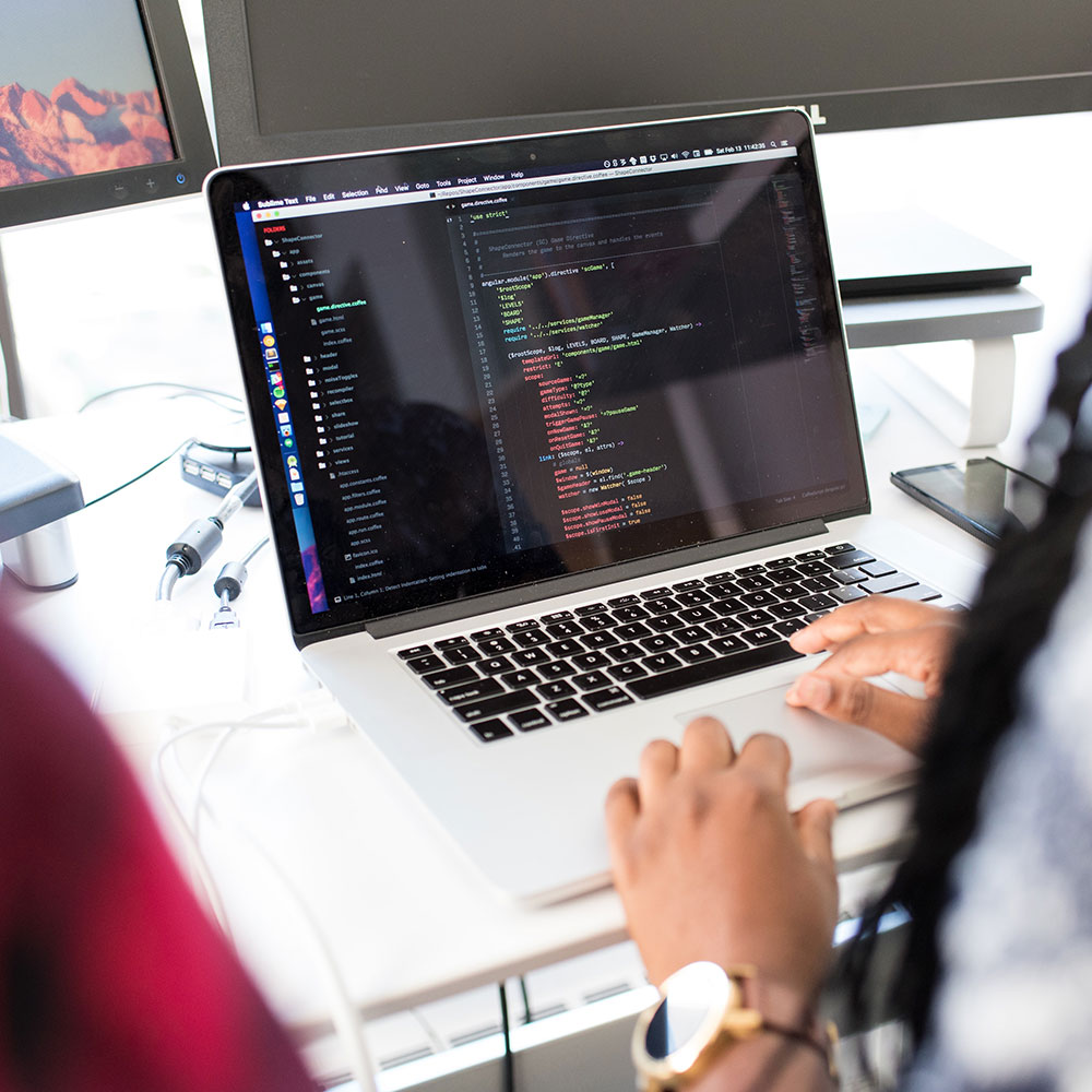 A tech worker types code onto a computer screen