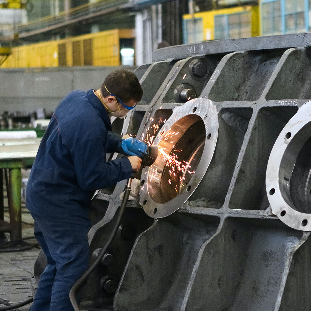 A welder uses machinery on a metal window