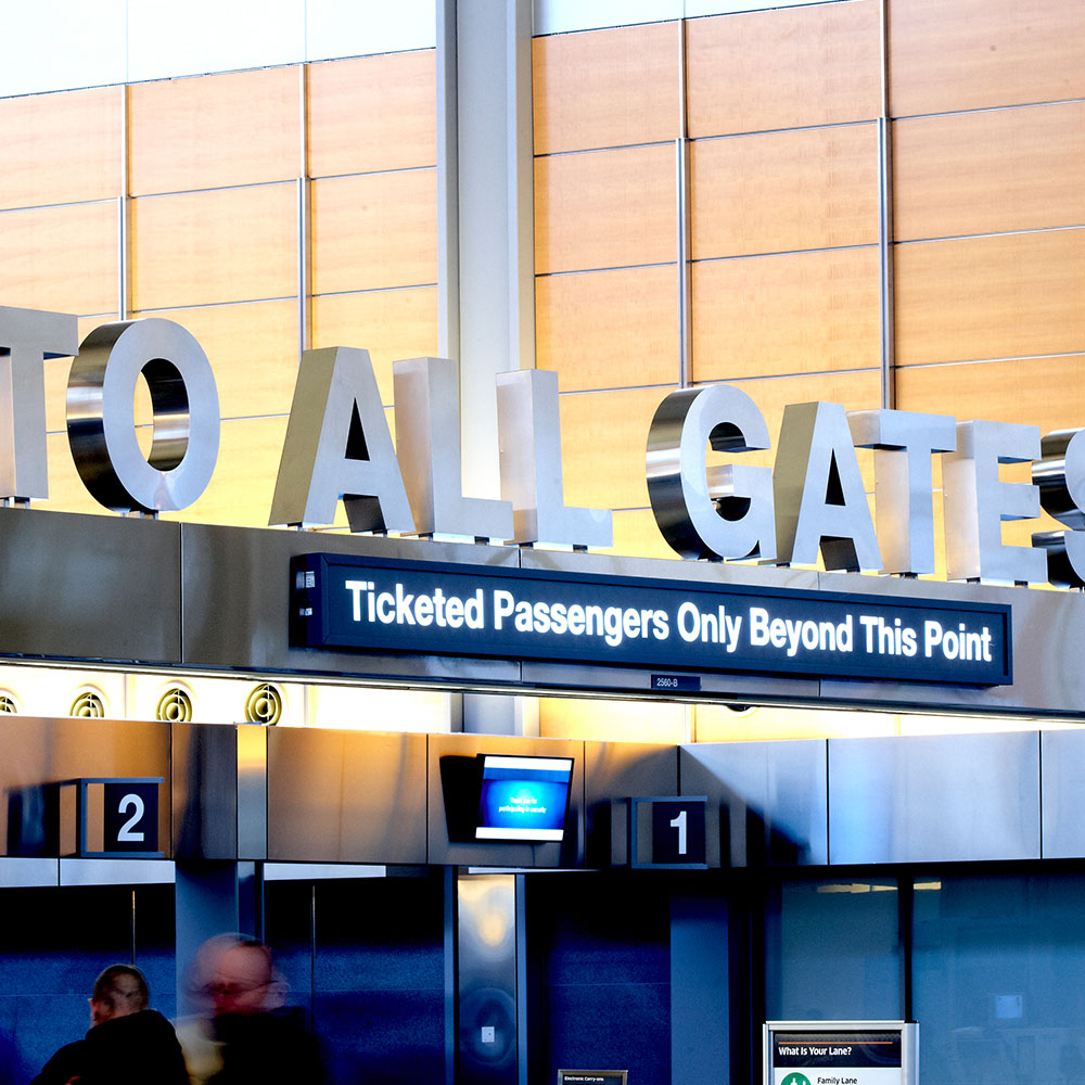 A metal display that says To All Gates and Ticketed Passengers Only Beyond This Point at RDU in Wake County