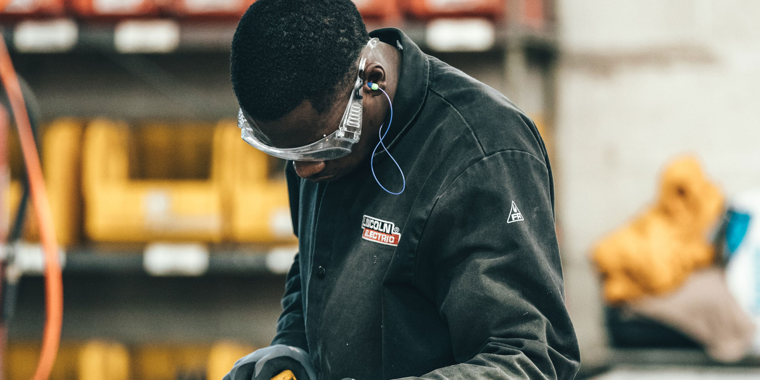 A male employee using a measuring tape to examine the width of a piece of metal in Wake County