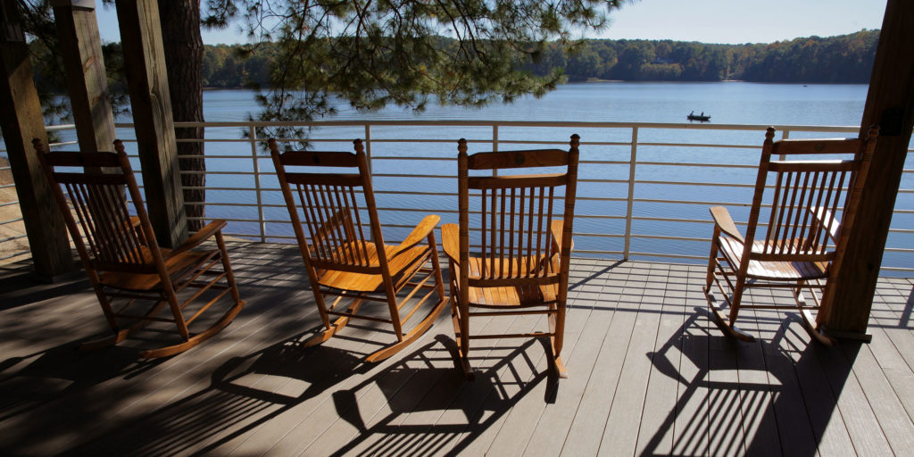 Four wooden rocking chairs overlooking a lake in Wake County