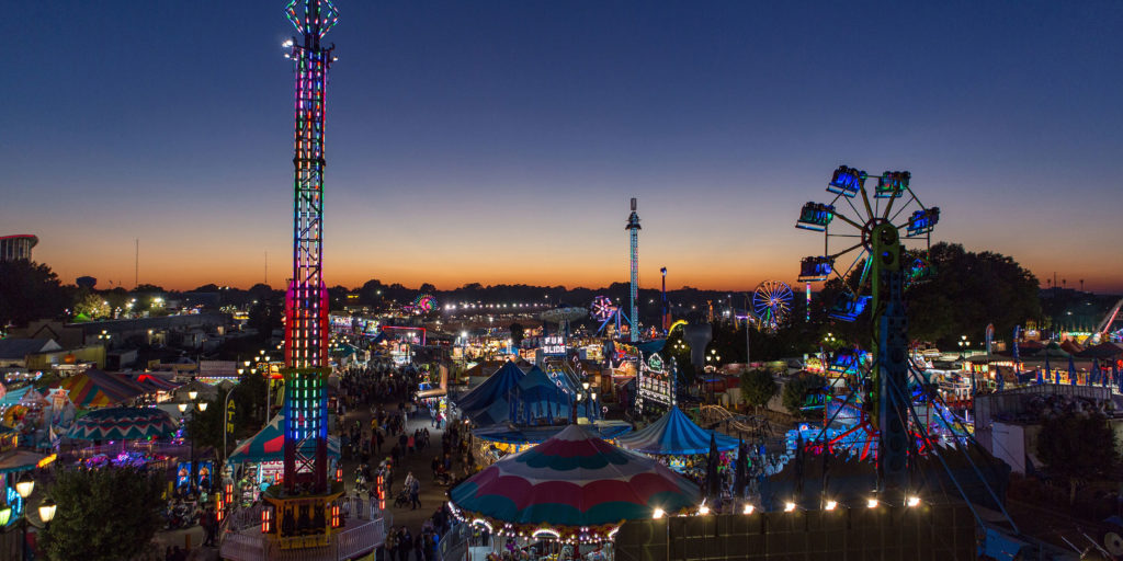 The skyline of the NC state fair at night with vibrant and colorful LED lights and dozens of fair rides in Wake County