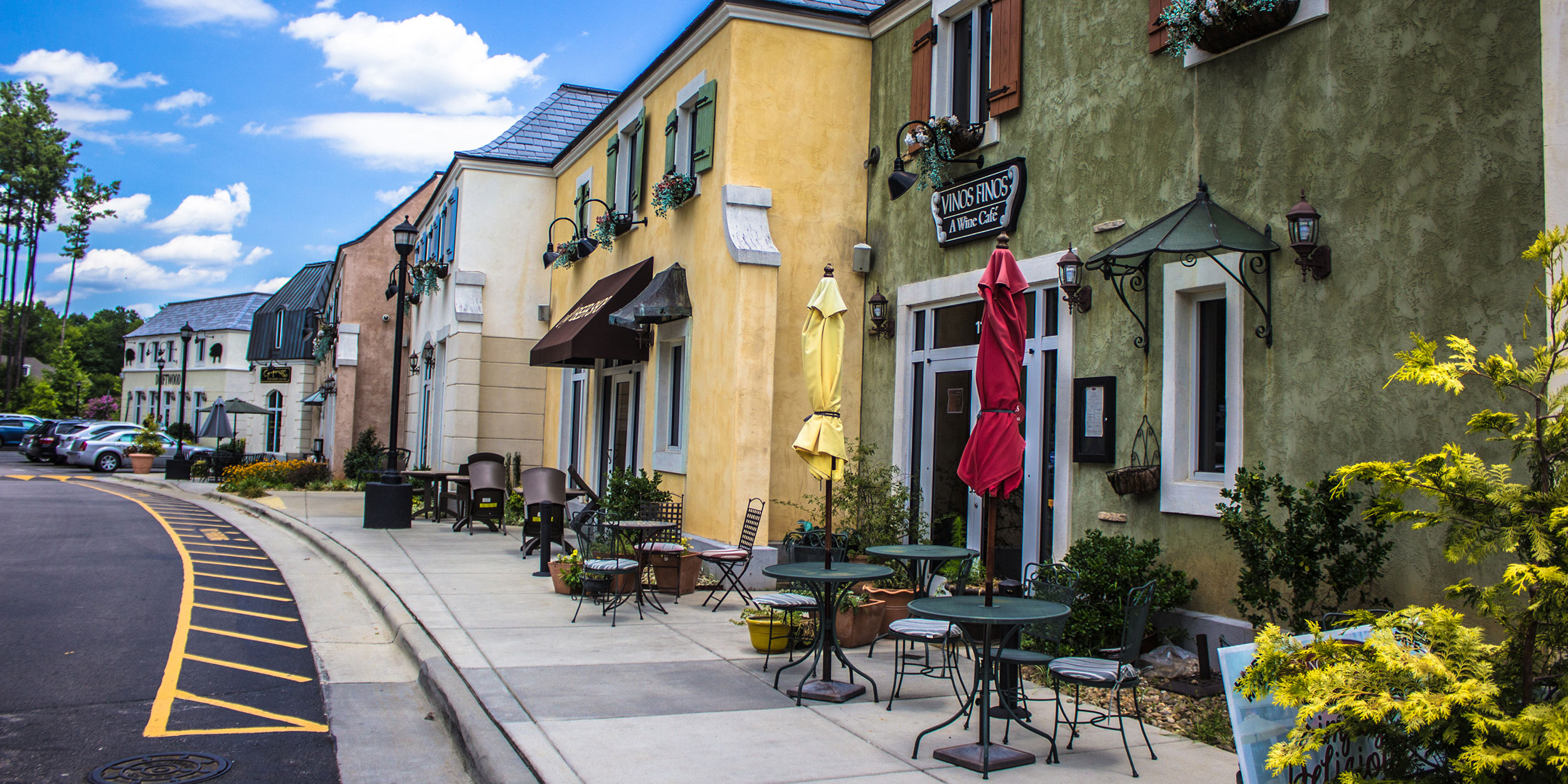 Rows of colorful buildings in Lafeyette Village with outdoor tables and flower boxes in the windows in Wake County