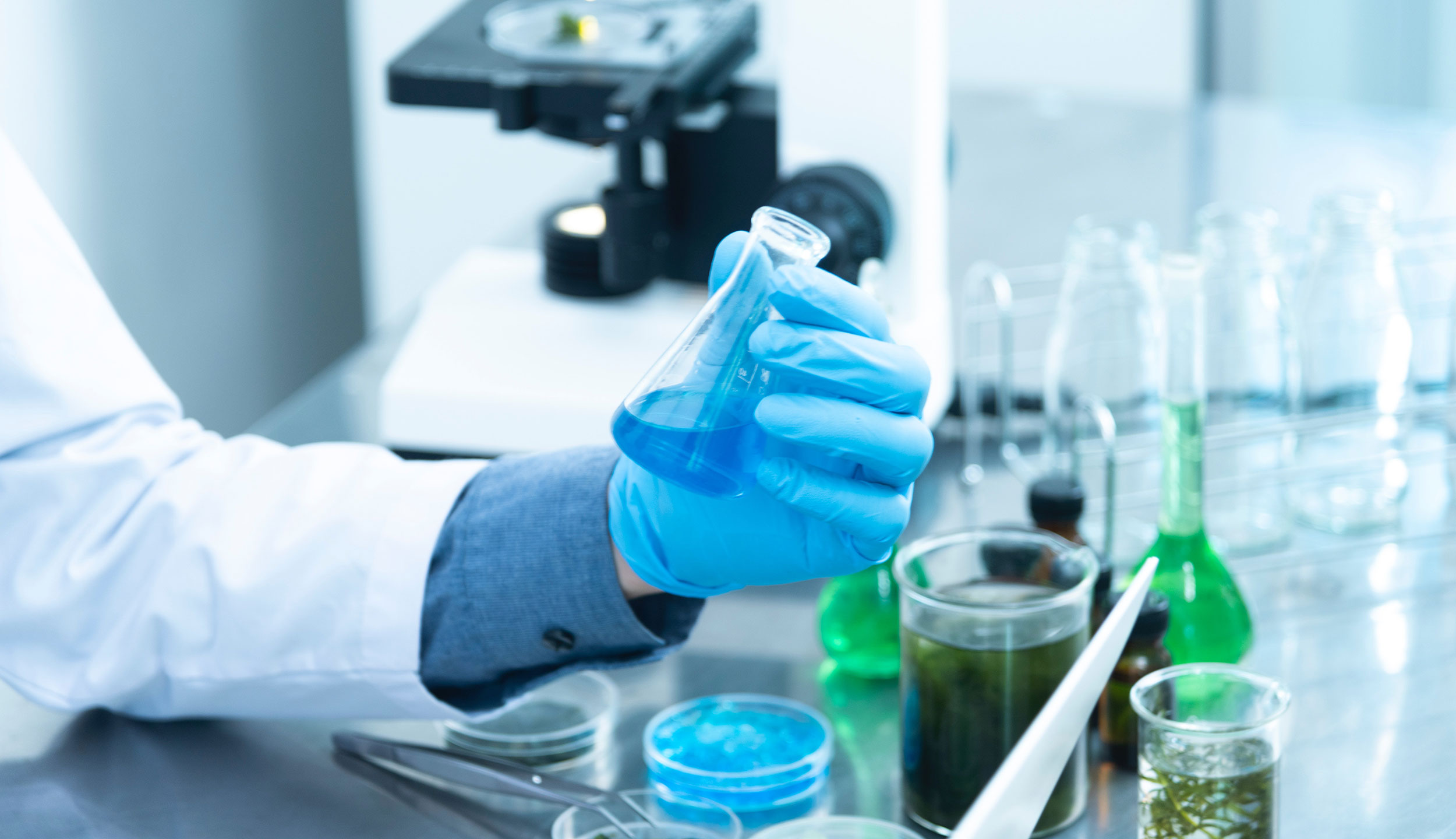 A person working in a lab holding a beaker.