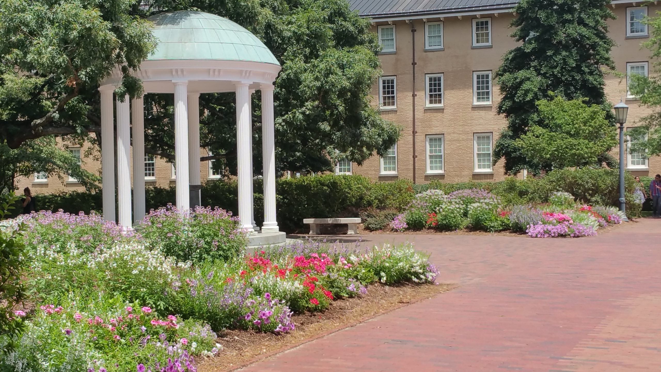 old well surrounded by greenery and buildings