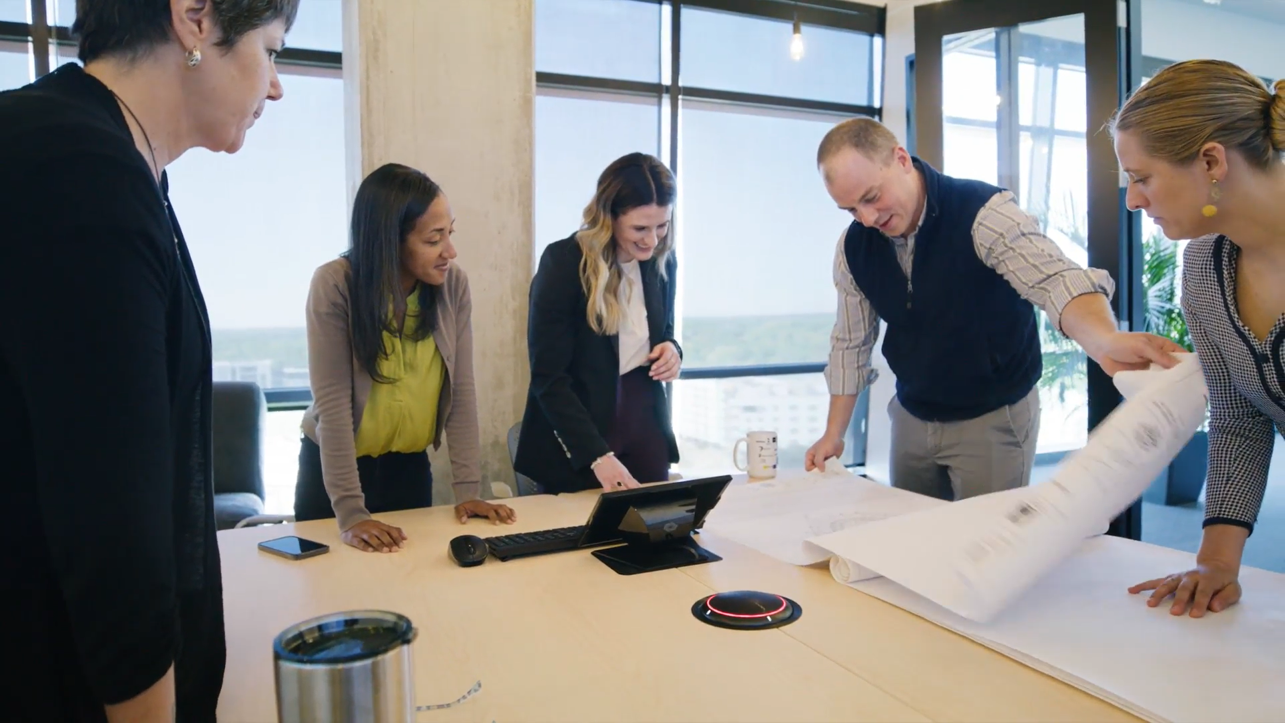 Five people viewing blueprints at architecture firm